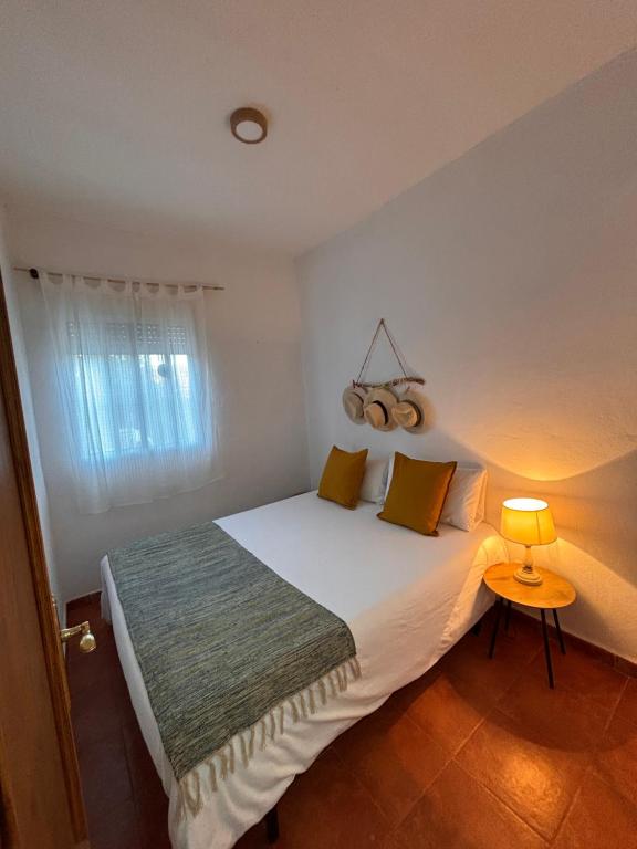 a bedroom with a large white bed with a lamp at La Molinera Rustic in Cártama