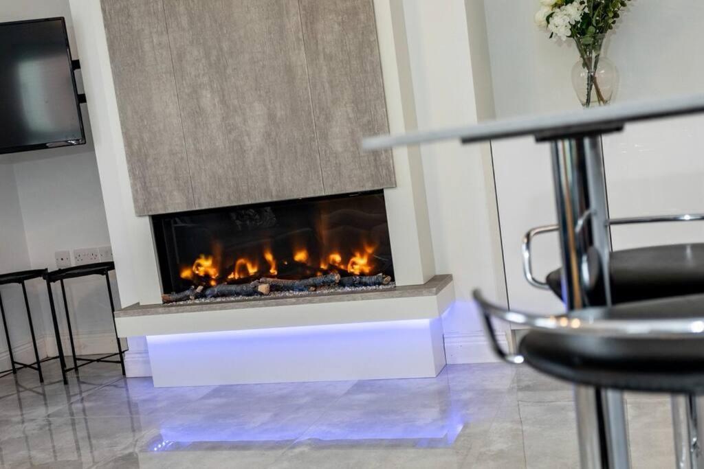a fireplace in a room with a table and chairs at Modern Apartment Portrush in Portrush