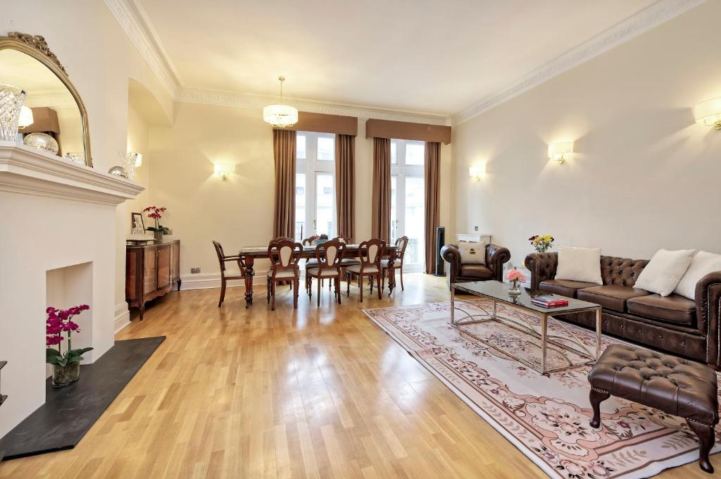 uma sala de estar com um sofá e uma mesa em Historic Whitehall flat in SW1 by UnderTheDoormat em Londres