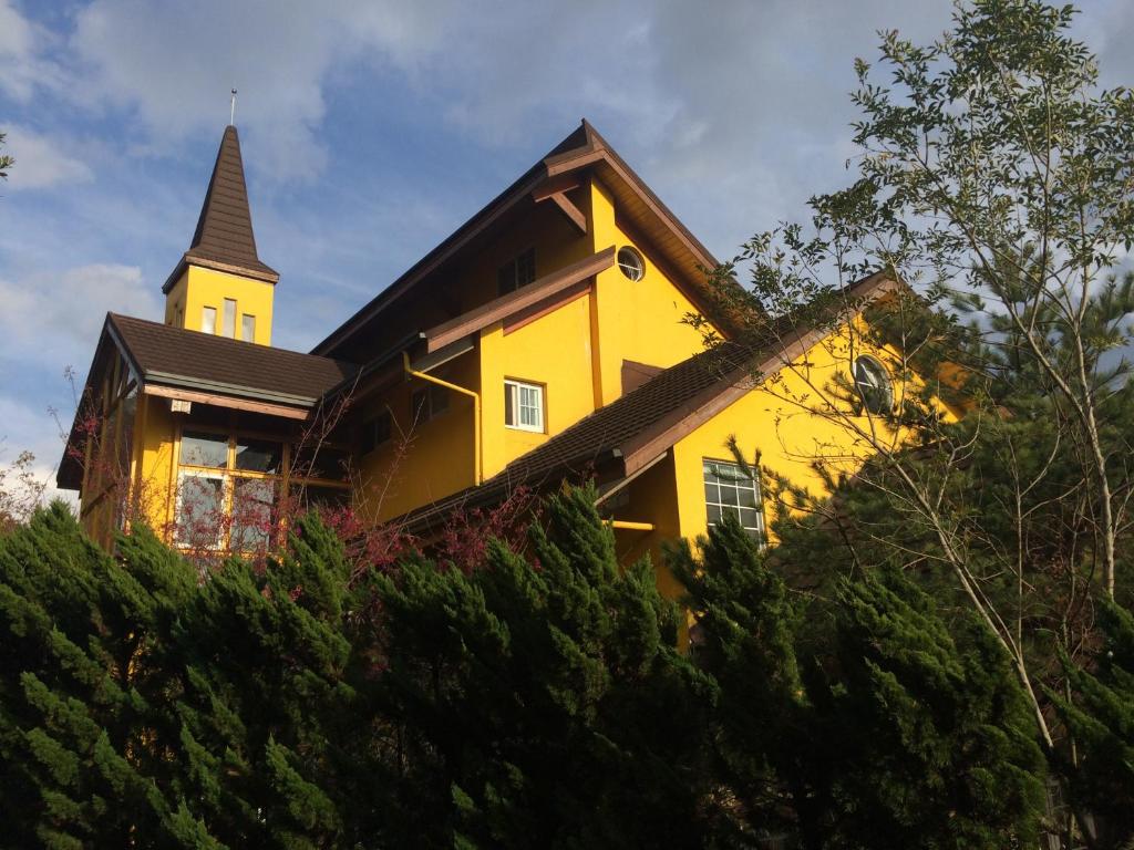 a yellow church with a steeple on top of trees at Euro Country Villa in Ren'ai