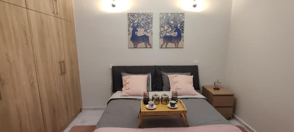 a bedroom with a bed with two paintings on the wall at City Hall studio apartment in Tríkala