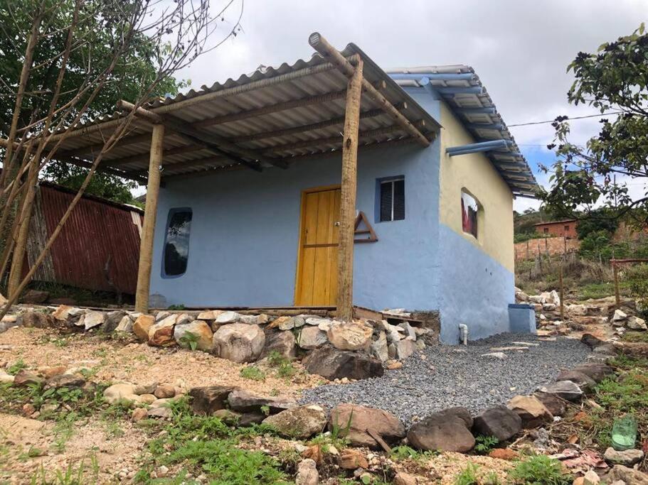 una pequeña casa azul con puerta de madera en CasaTupy Pousada, en Botumirim