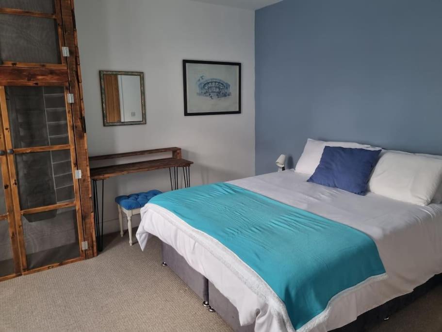 a bedroom with a bed with a blue blanket on it at 6 En-Suite Bedrooms; Garden; Driveway;Pet Friendly in Bournemouth