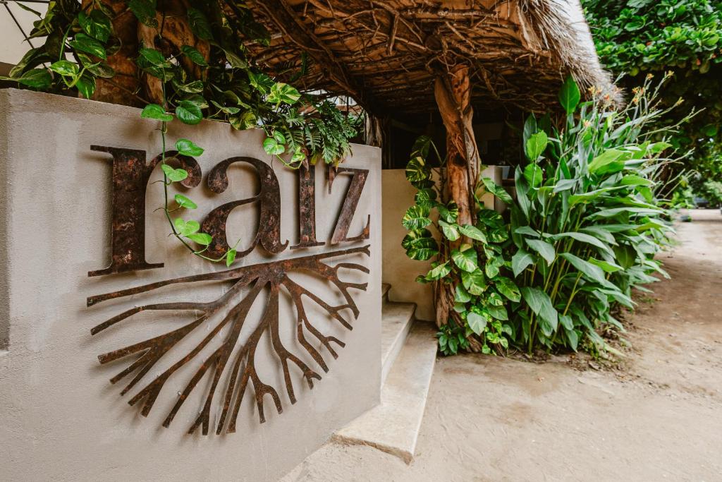 a sign with a number on a wall with plants at Raíz Hotel Boutique in Puerto Escondido