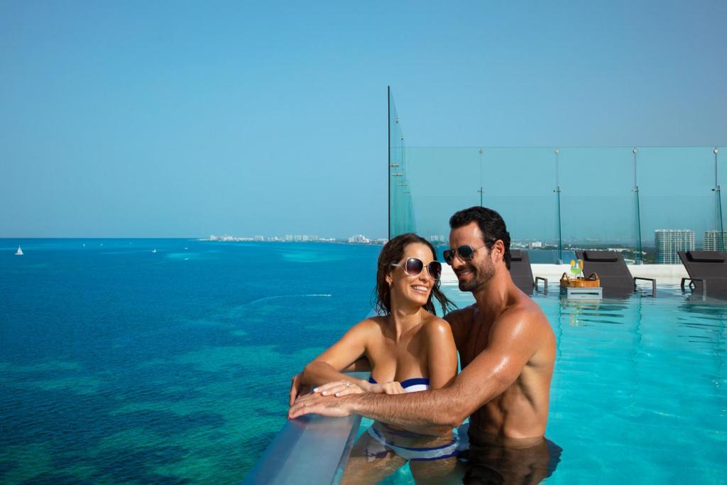 a man and a woman in the water at a pool at Dreams Vista Cancun Golf & Spa Resort in Cancún