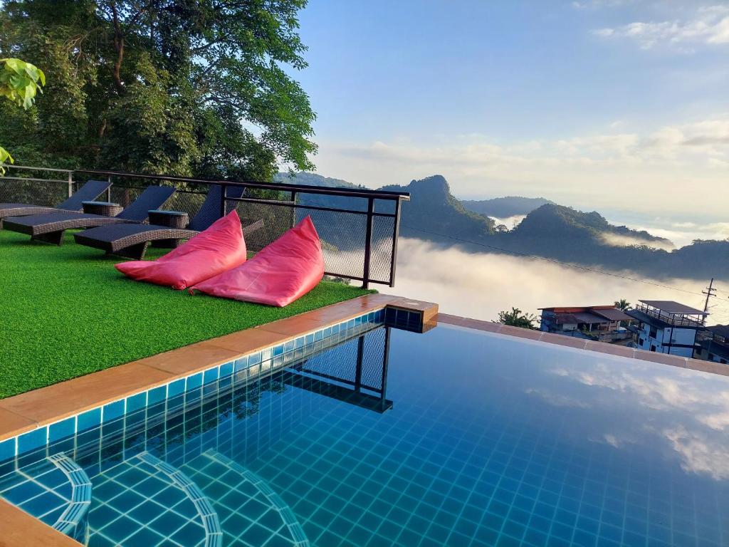 Ban Pha Mi的住宿－Oasis Phamee，一个带红色枕头的游泳池,享有山景