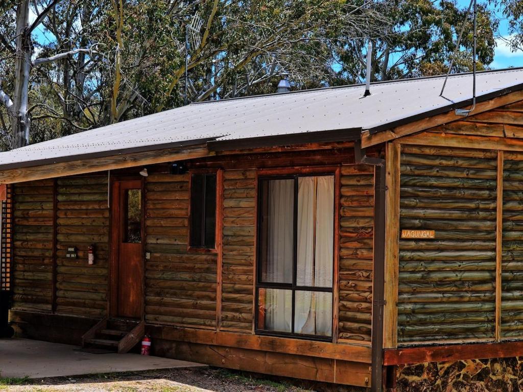 Cabaña de madera con puerta y ventana en Cabin 3 - Snowy Accommodation, en Adaminaby