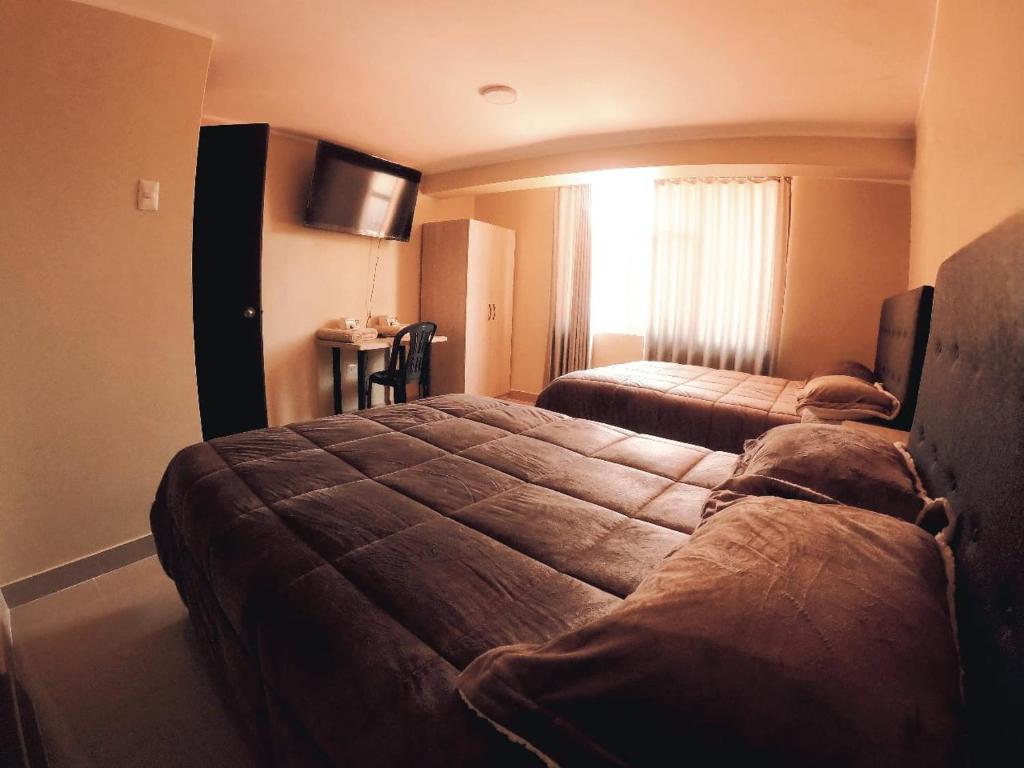 une chambre d'hôtel avec un lit et une télévision dans l'établissement CASONA PIURA, à Huancayo