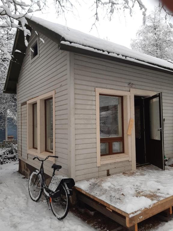 a bike parked outside of a house in the snow at Garden Chamber in Rovaniemi