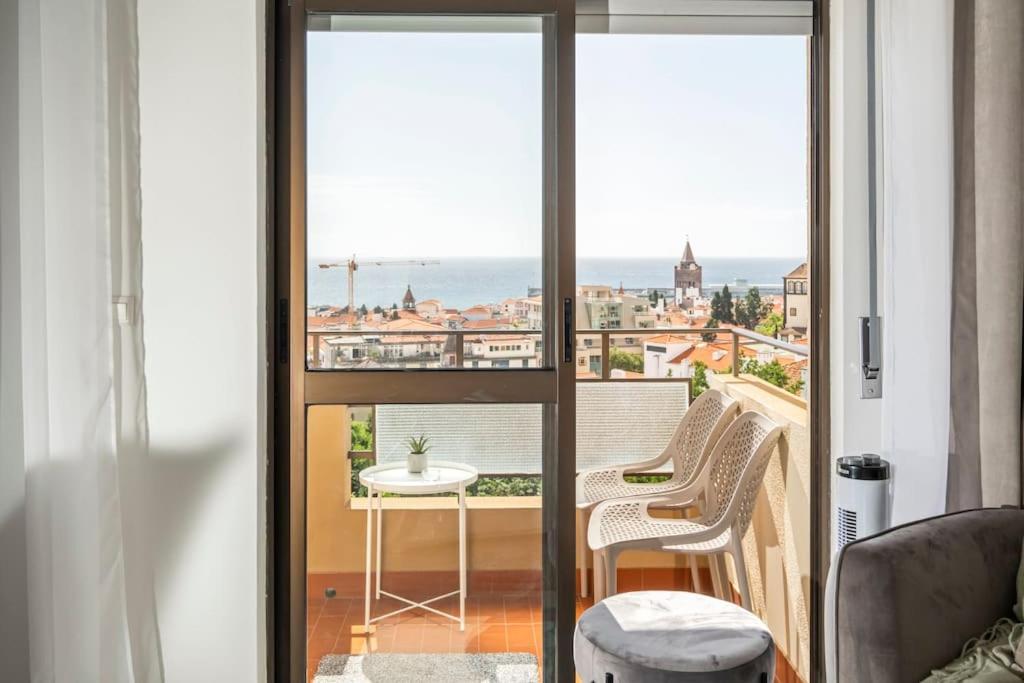 a room with a balcony with a table and chairs at SUPER T3 Elias Garcia in Funchal