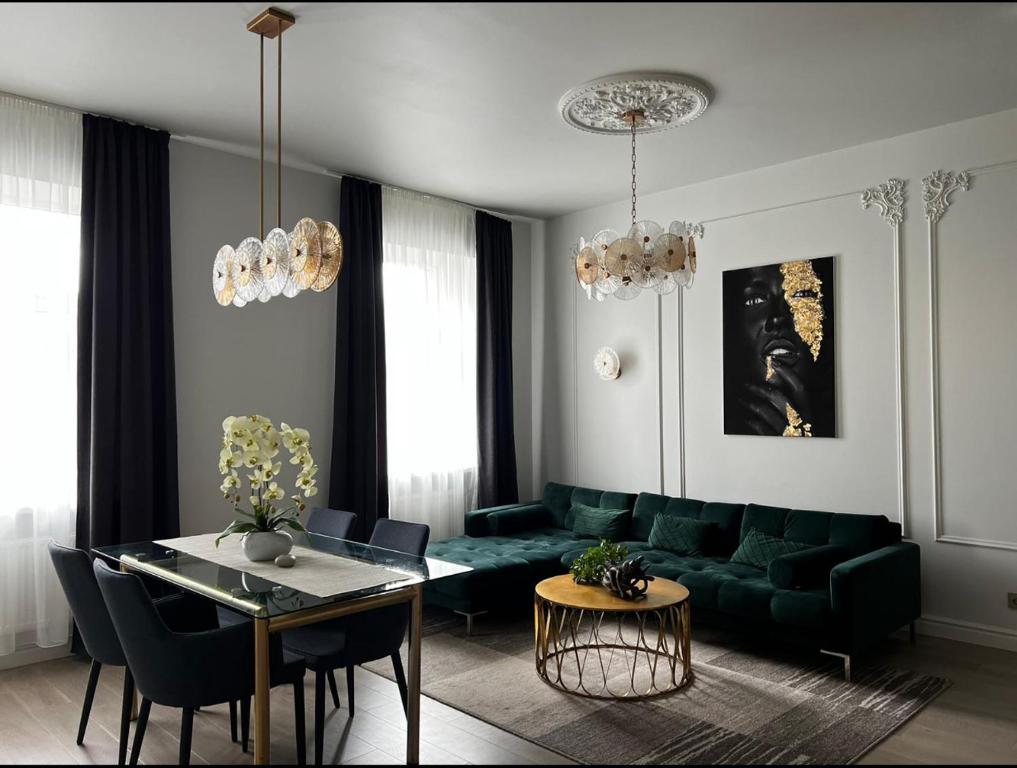 a living room with a green couch and a table at Raina apartment Gold in Jelgava
