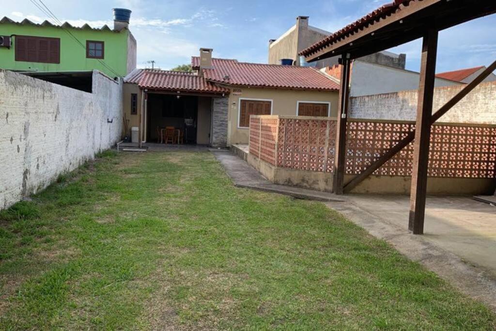 ein Hof eines Hauses mit einem Zaun in der Unterkunft Casa para 6 + piscina, in Rio Grande