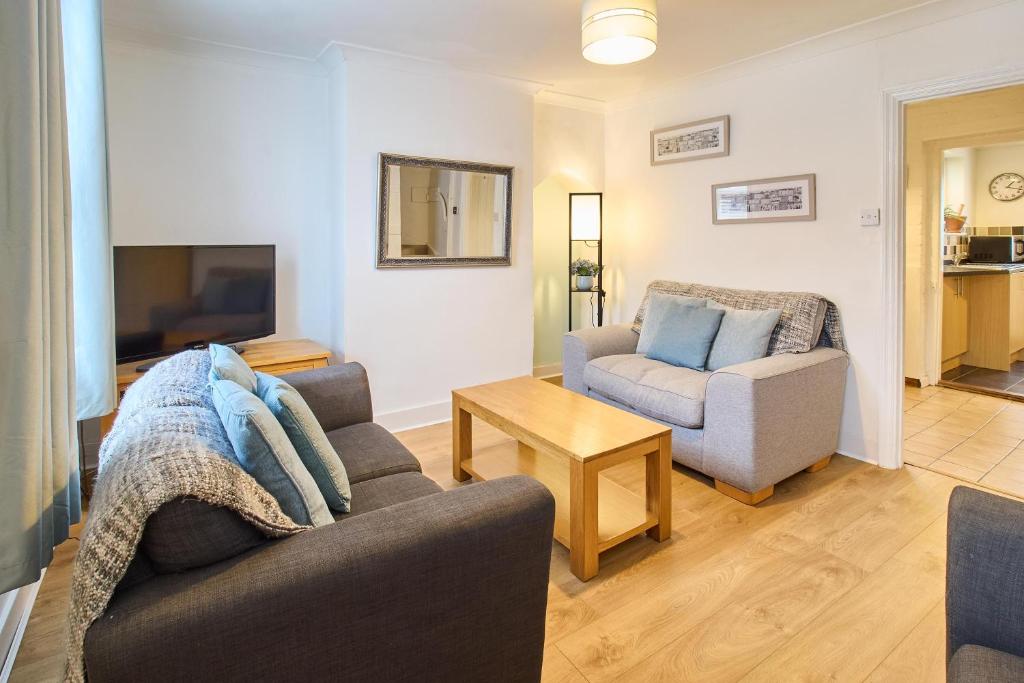 uma sala de estar com um sofá e uma cadeira em Host & Stay - Prospect Place em Canterbury