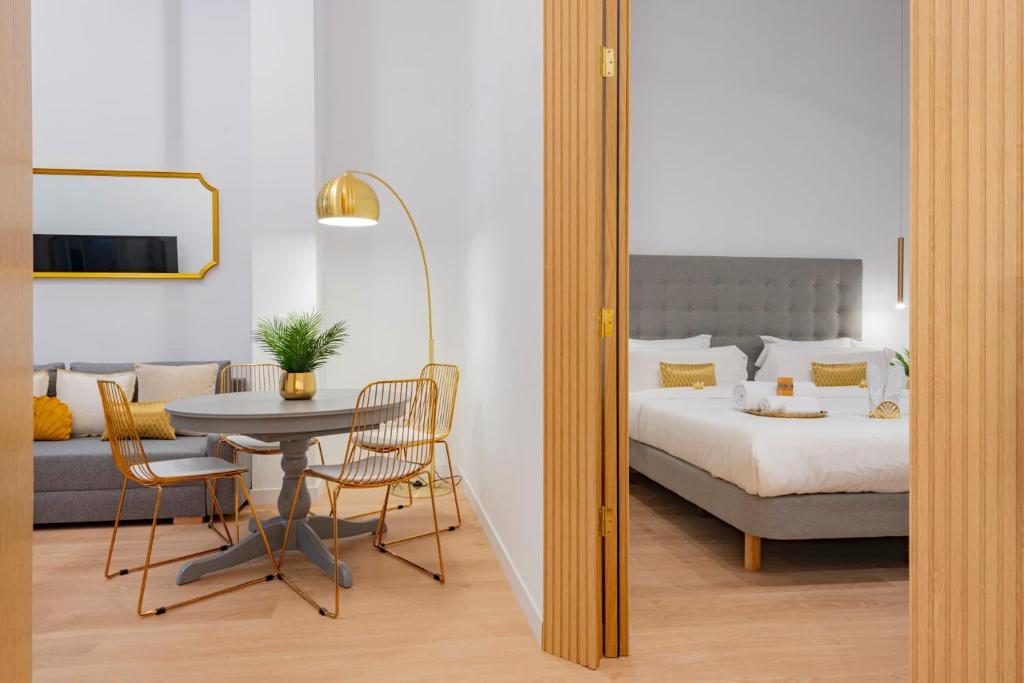 Schlafzimmer mit einem Bett, einem Tisch und Stühlen in der Unterkunft Smart Apartment Near Puerta Del Sol in Madrid