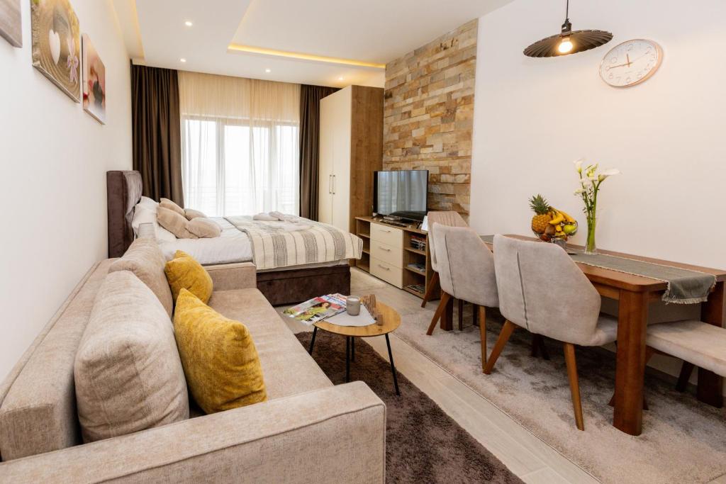 Una sala de estar con un sofá y un comedor. en Apartman Stankovic Milmari Resort, en Kopaonik