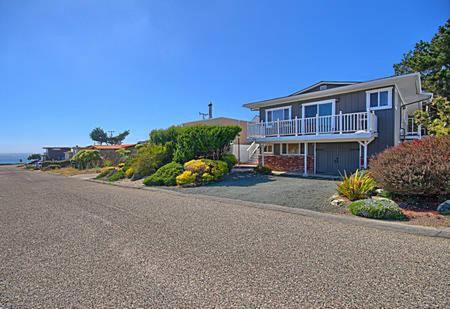 a large house on a road next to the ocean at 275 Stafford in Cambria