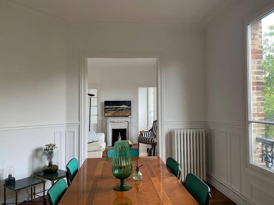 une salle à manger avec une table et des chaises vertes dans l'établissement Le Cœur de l’Île Saint-Louis, you will love it!, à Paris