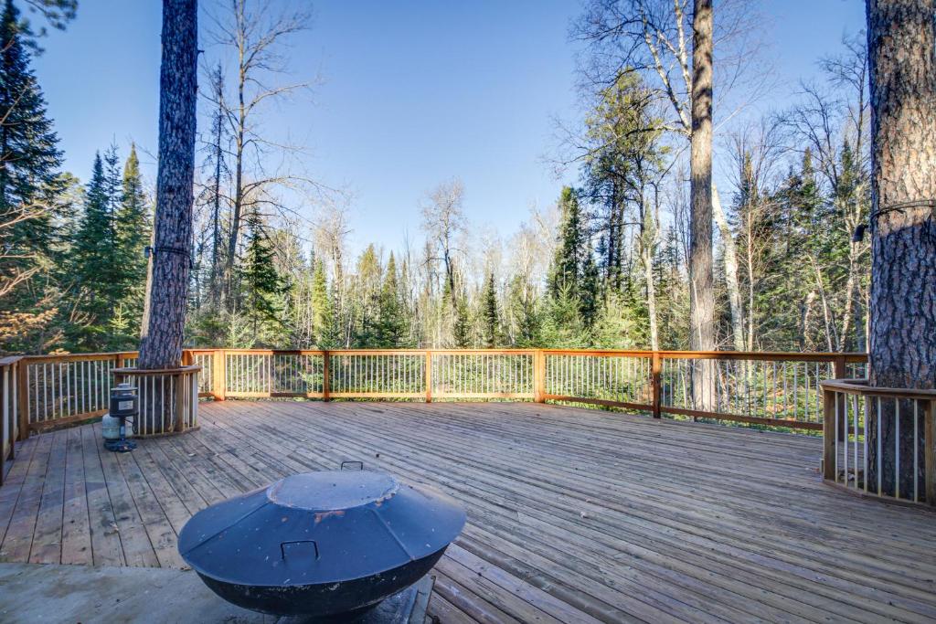 a wooden deck with a bench on top of it at Peaceful Hibbing Getaway Heated Floors, Fire Pit! in Hibbing