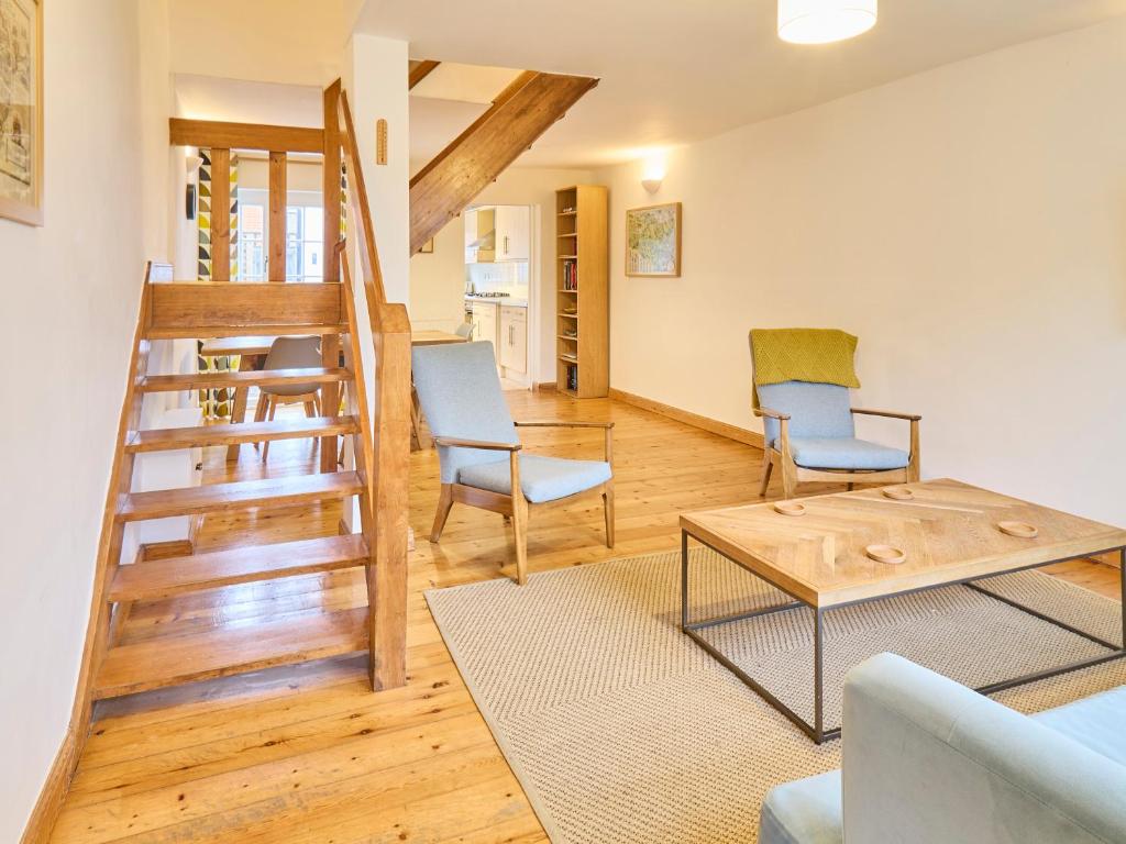 a living room with a staircase and two chairs at Host & Stay - New Street in Canterbury