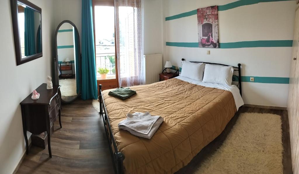 1 dormitorio con 1 cama en una habitación con espejo en Dimitris & Despoinas Guest House, en Tripolis