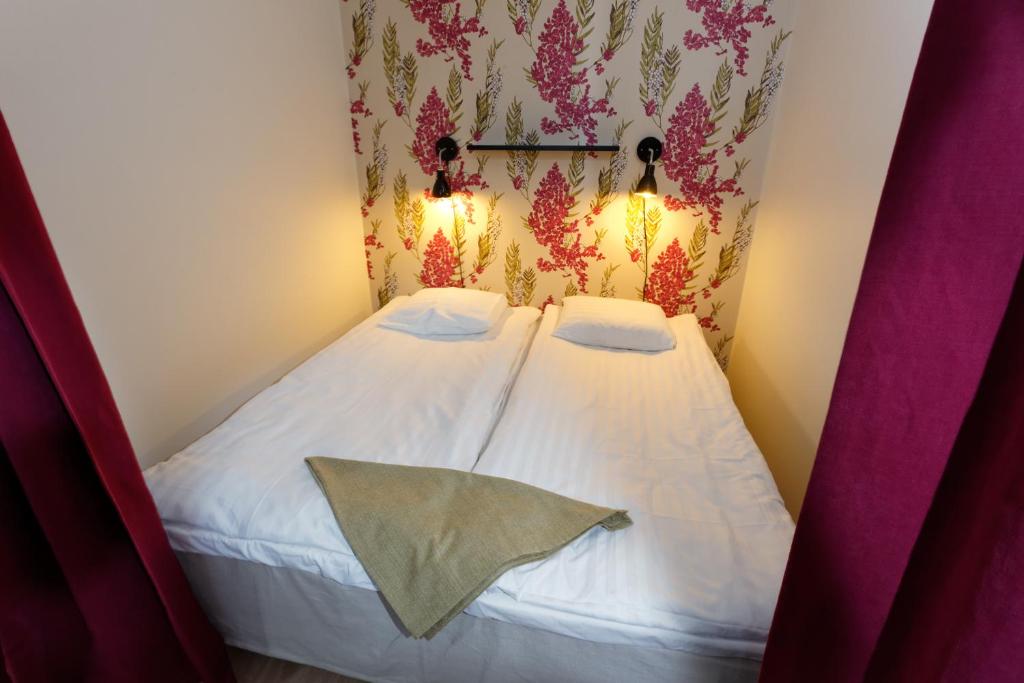 a small bed in a room with two pillows at Forenom Serviced Apartments Helsinki Kruununhaka in Helsinki