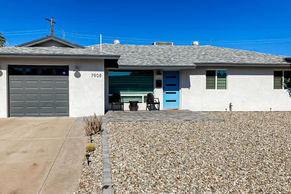 een wit huis met een blauwe deur en een patio bij Lone Palm Terrace in Scottsdale