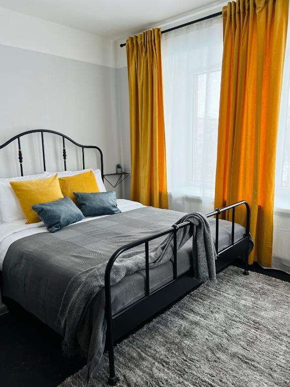 um quarto com uma cama com cortinas cor de laranja em Mežaparka apartamenti em Jēkabpils