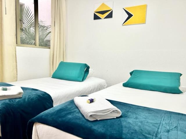 Dos camas en una habitación de hotel con toallas encima. en Aparta_Suite_Sogamoso, en Sogamoso