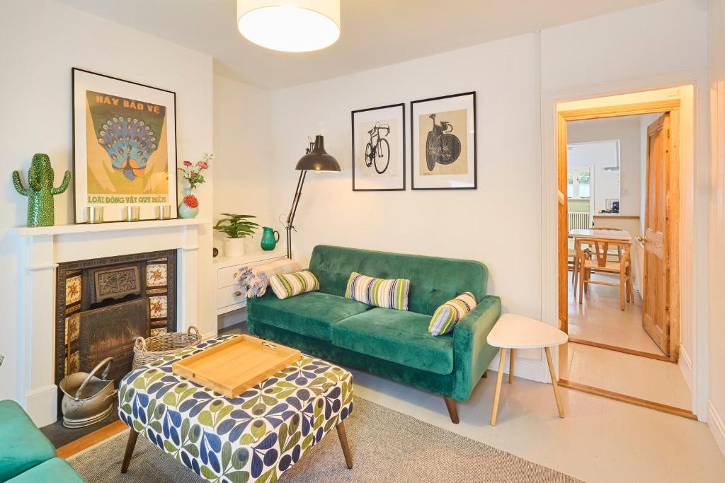 uma sala de estar com um sofá verde e uma mesa em Host & Stay - Sparrows Nest em Whitstable
