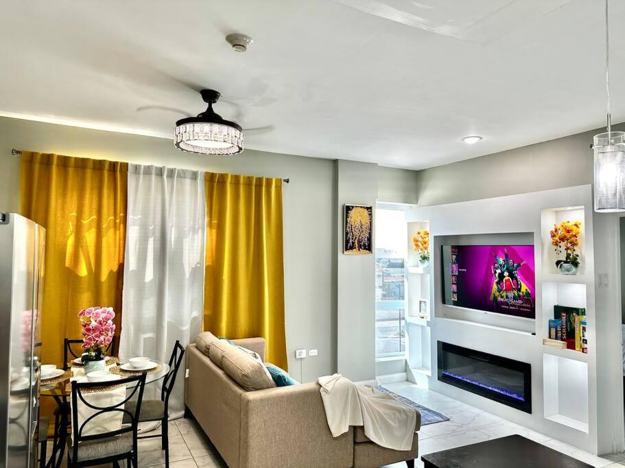 uma sala de estar com um sofá e uma televisão em BYRD’S Oasis Apartment em Kingston