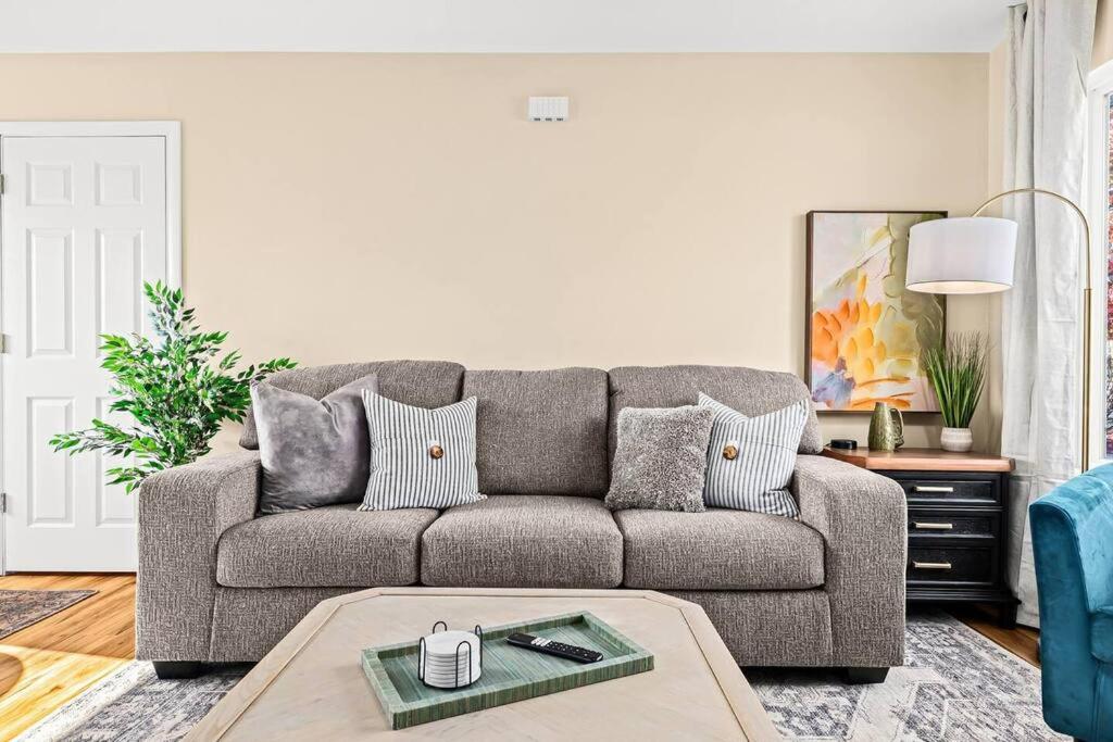 uma sala de estar com um sofá e uma mesa em New Cozy Lower Flat in Roseville em Roseville