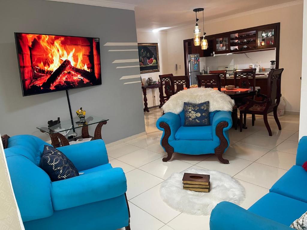 sala de estar con sillas azules y chimenea en Apartamento de 2 Habitaciones con Seguridad y Cámaras, en Mendoza