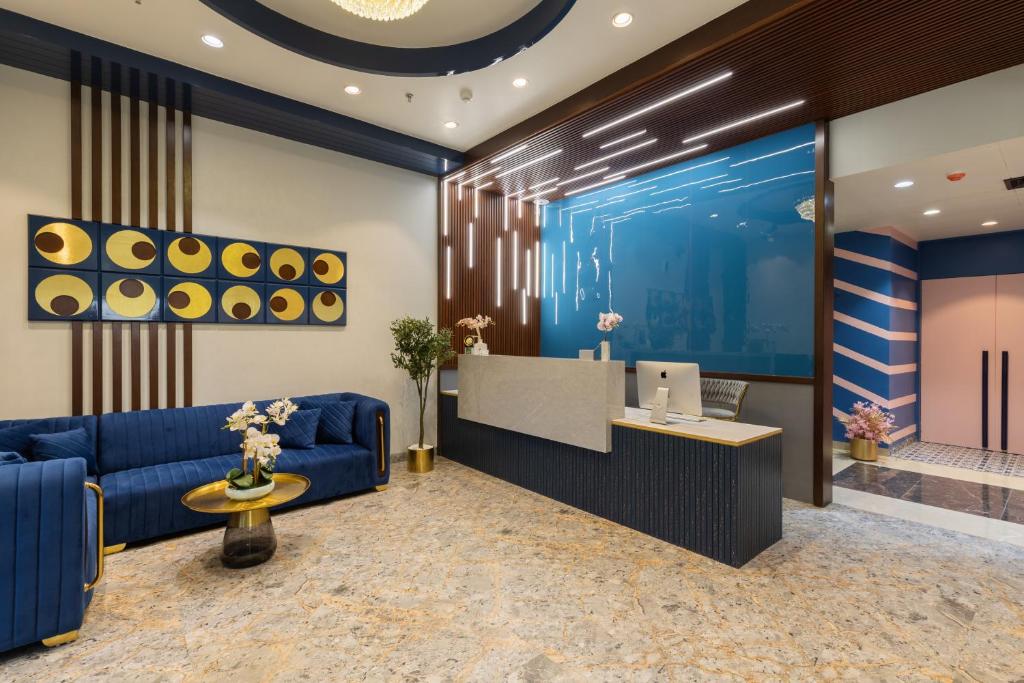 ジャイプールにあるRoyal Rawal - Luxury Boutique Hotelの青いソファとデスク付きのロビー