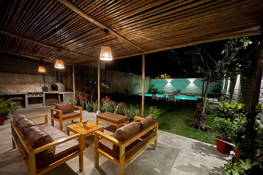 a patio with two couches and a table at Hermosa casa de campo con piscina en Cieneguilla in Cieneguilla