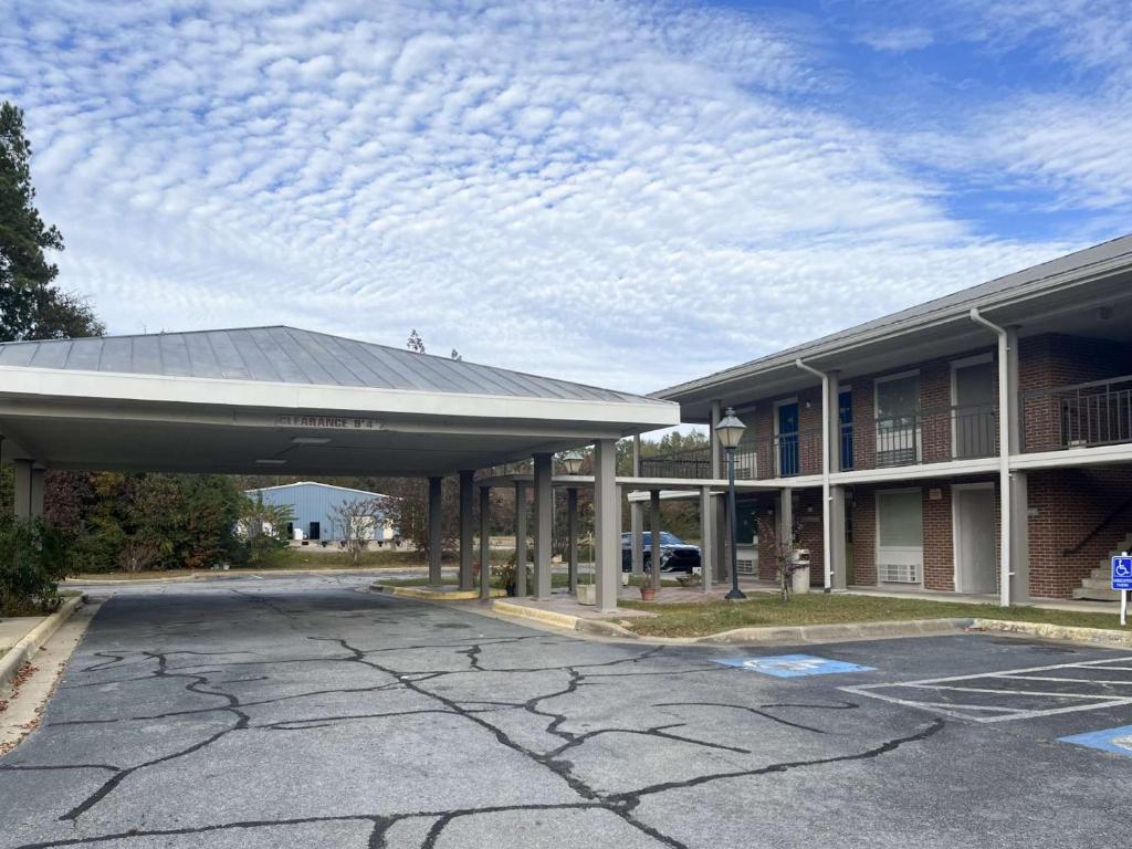 un aparcamiento vacío frente a un edificio en Motel 6 Sandersville, GA, en Sandersville