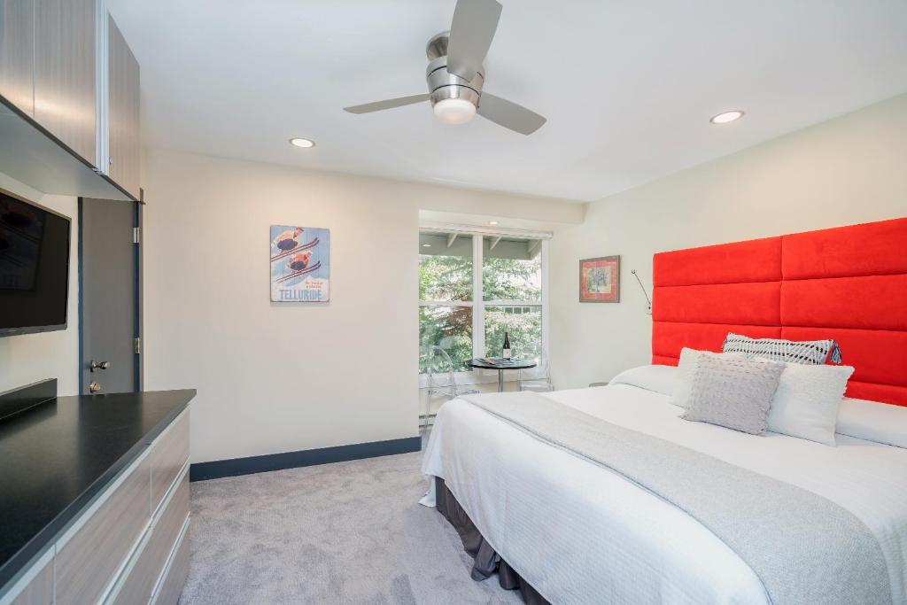 1 dormitorio con 1 cama grande y cabecero rojo en Mountainside Inn 419-21 Hotel Room, en Telluride