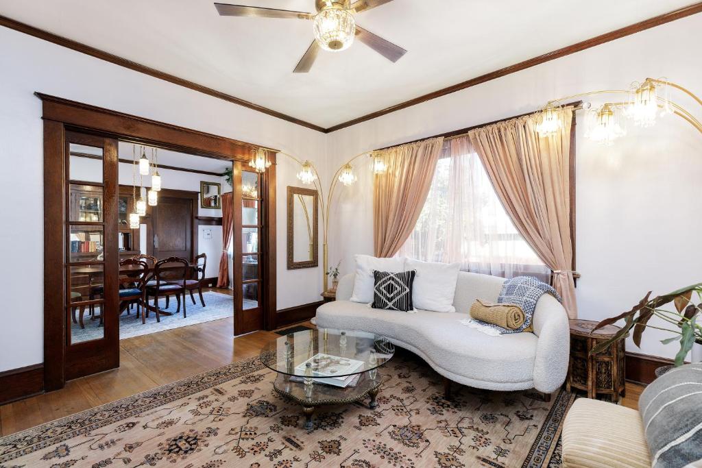 ein Wohnzimmer mit einer weißen Couch und einem Tisch in der Unterkunft The Betty - A 1920s Vintage Bungalow in Portland