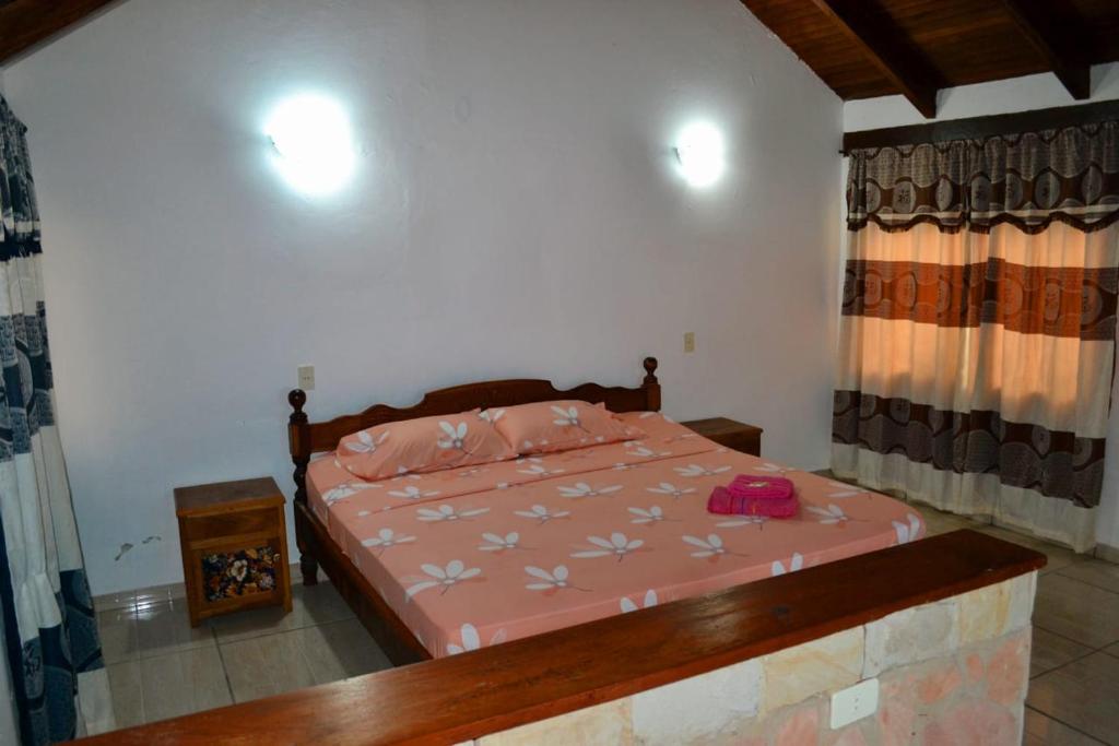 a bedroom with a bed with a pink comforter at Lago Manantial in Independencia