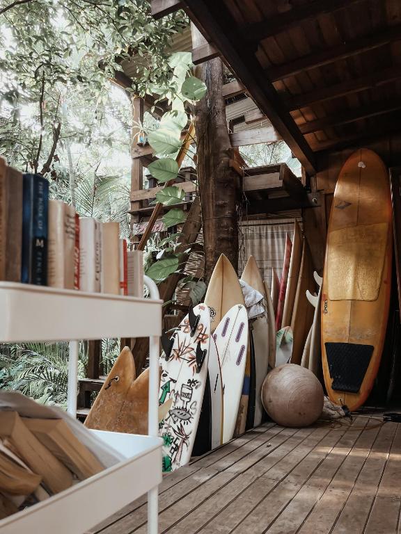 a group of surfboards and books on a porch at La Punta surfhouse in Puerto Escondido