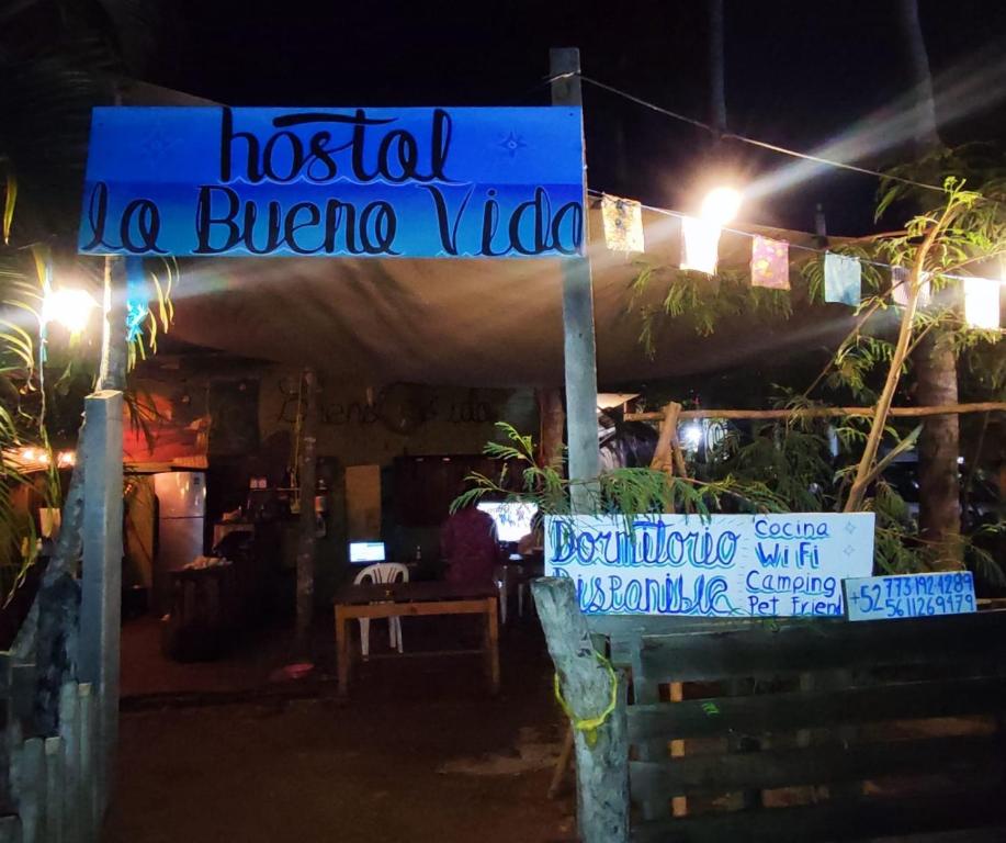 een bord voor een hotel loc buena vida 's nachts bij Hostal La Buena Vida Mazunte in Mazunte