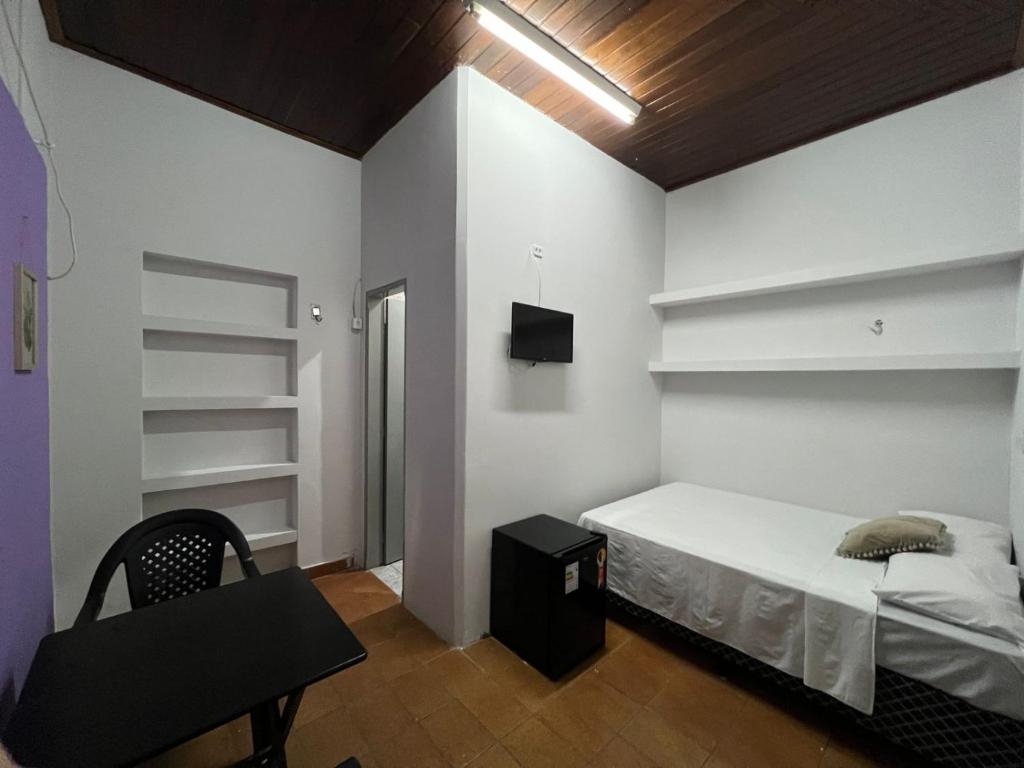 1 dormitorio con cama, silla y estanterías en Casa Jardim Guest House, en Carolina