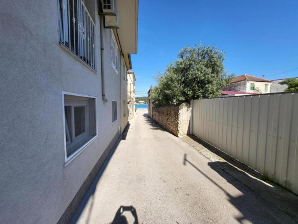 a shadow of a person on a street next to a building at Apartments by the sea Tisno, Murter - 22006 in Tisno