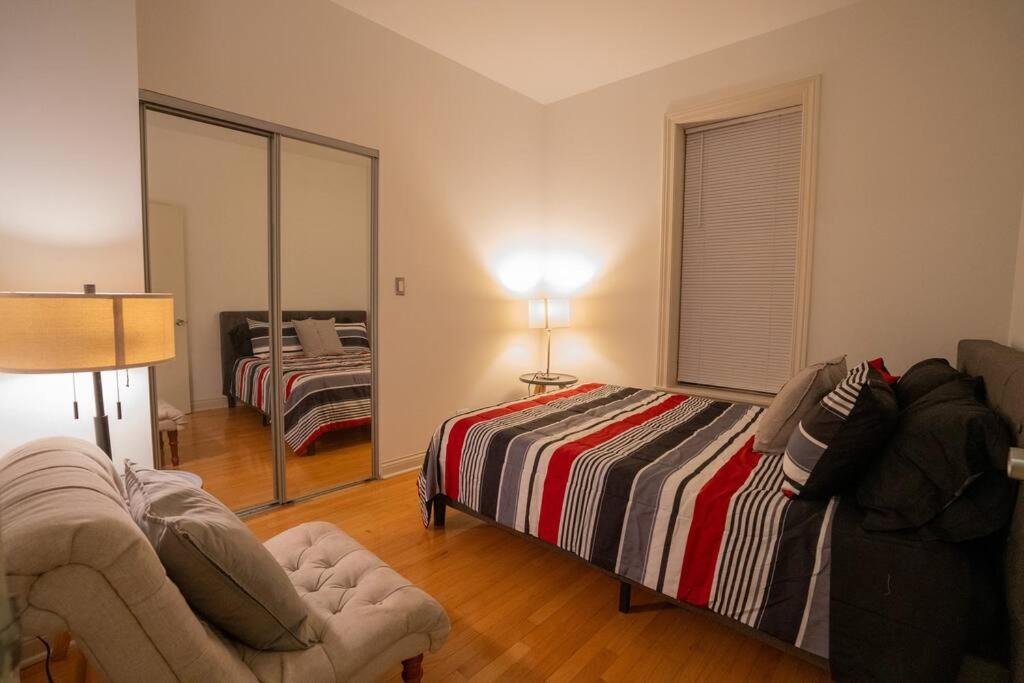 ein Schlafzimmer mit einem Bett, einem Sofa und einem Spiegel in der Unterkunft Modern 4BR in Hyde Park, Walk to University in Chicago