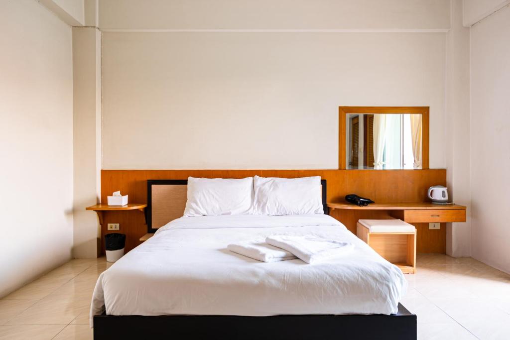 1 dormitorio con 1 cama blanca grande y cabecero de madera en GO INN Suvarnabhumi Airport en Lat Krabang