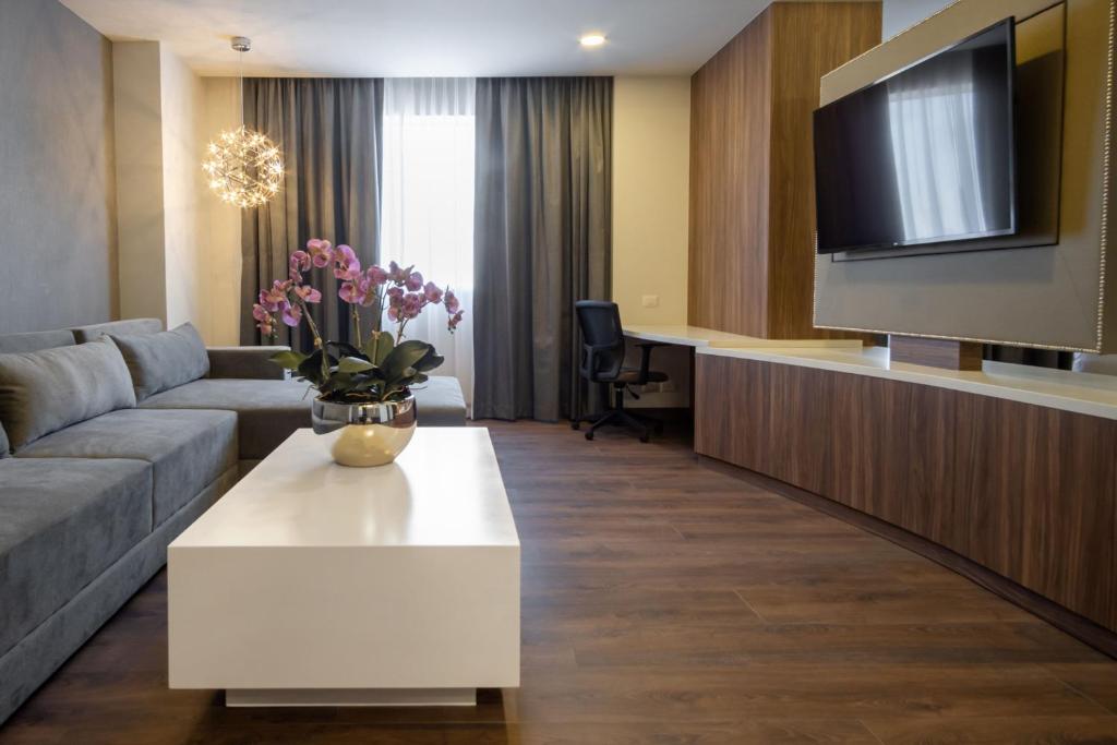 a living room with a couch and a tv at Gran Hotel Expo Guadalajara by HNF in Guadalajara