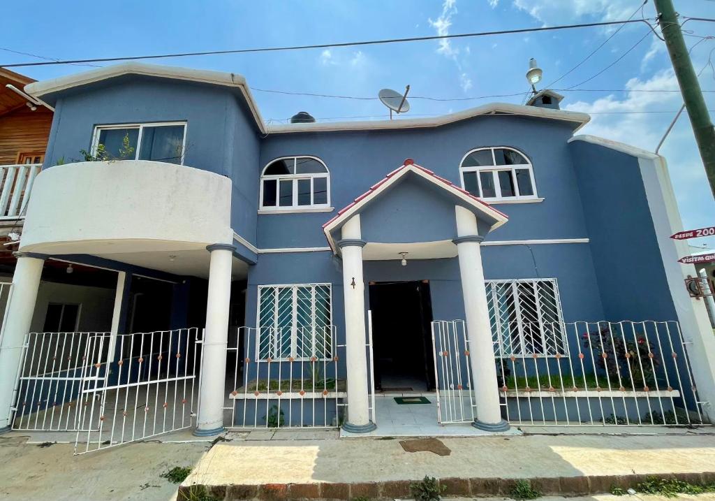 una casa azul con columnas blancas en La Casa del Profe 