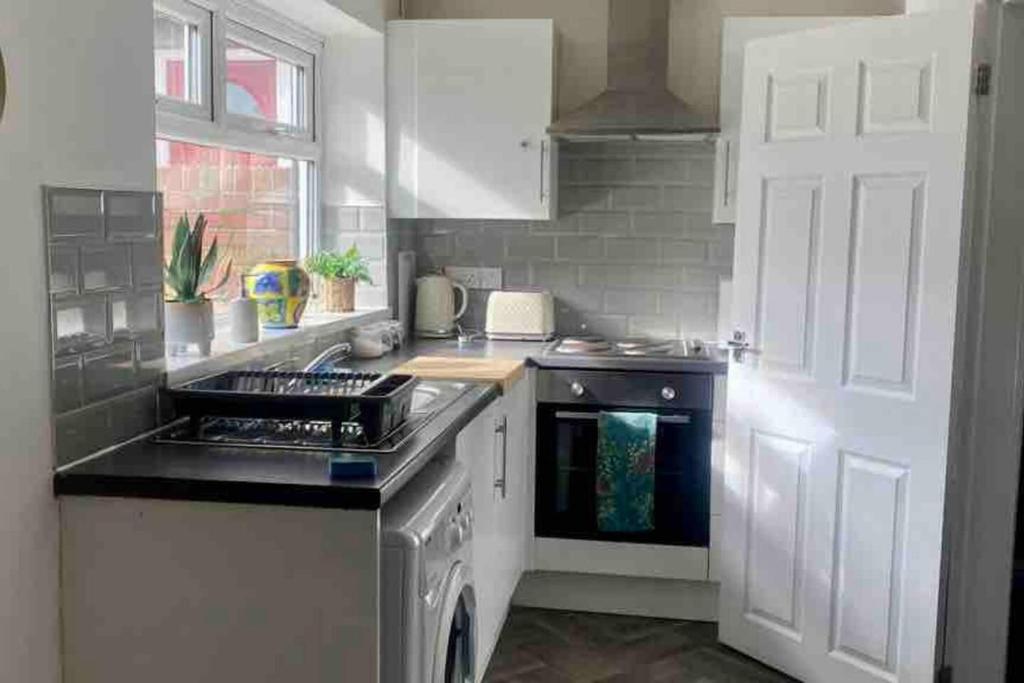 a kitchen with a sink and a stove top oven at WiFi Free Secure Parking Stadium & City Centre in Sunderland