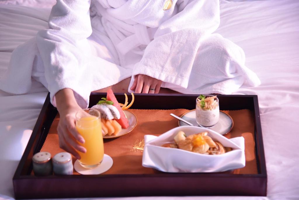 een persoon met een dienblad met eten en drinken bij InterContinental Quanzhou, an IHG Hotel in Quanzhou