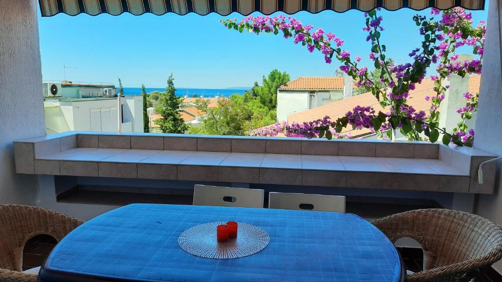 a blue table with a red candle on top of a balcony at Mirjana Gajac in Gajac