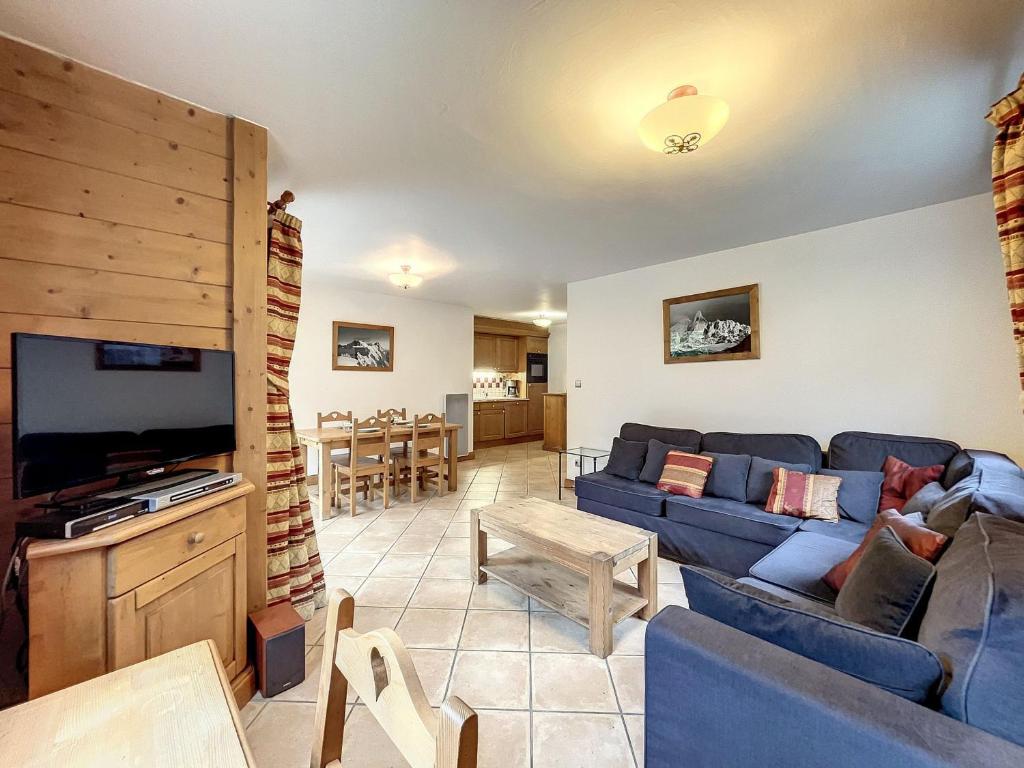 uma sala de estar com um sofá azul e uma televisão em Appartement Chamonix-Mont-Blanc, 3 pièces, 6 personnes - FR-1-507-76 em Chamonix-Mont-Blanc